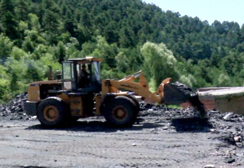 图为工作人员正在对违规煤场进行清理